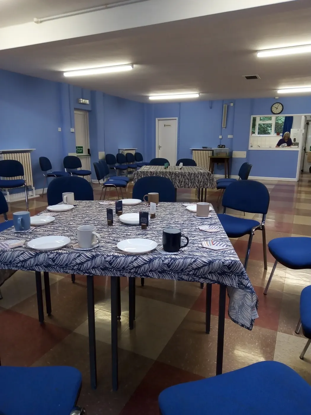 Tables laid with cloths and mugs for the coffee morning