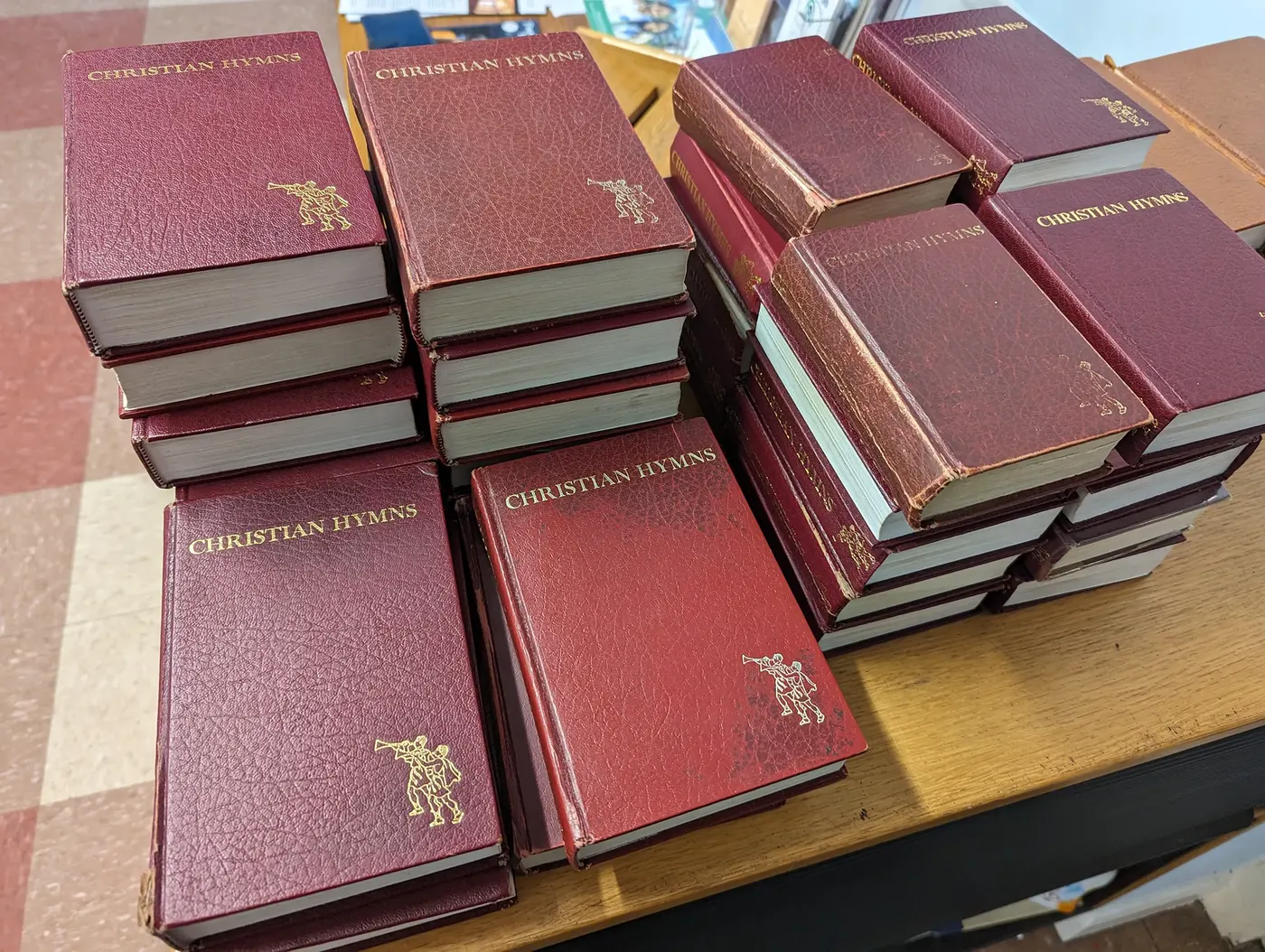A stack of red Christian Hymns books